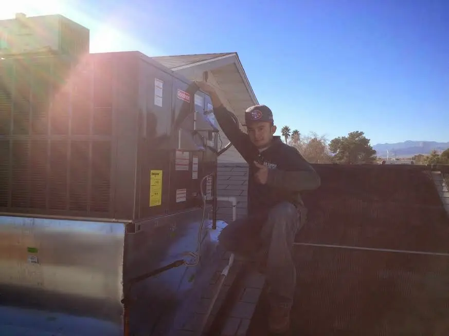 HVAC technician performing Heat Pump Repair on a rooftop unit in Windcrest