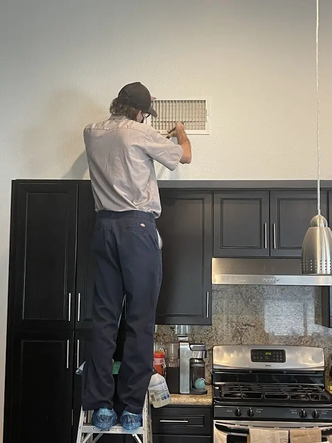 Technician inspecting an air vent during HVAC service in Windcrest